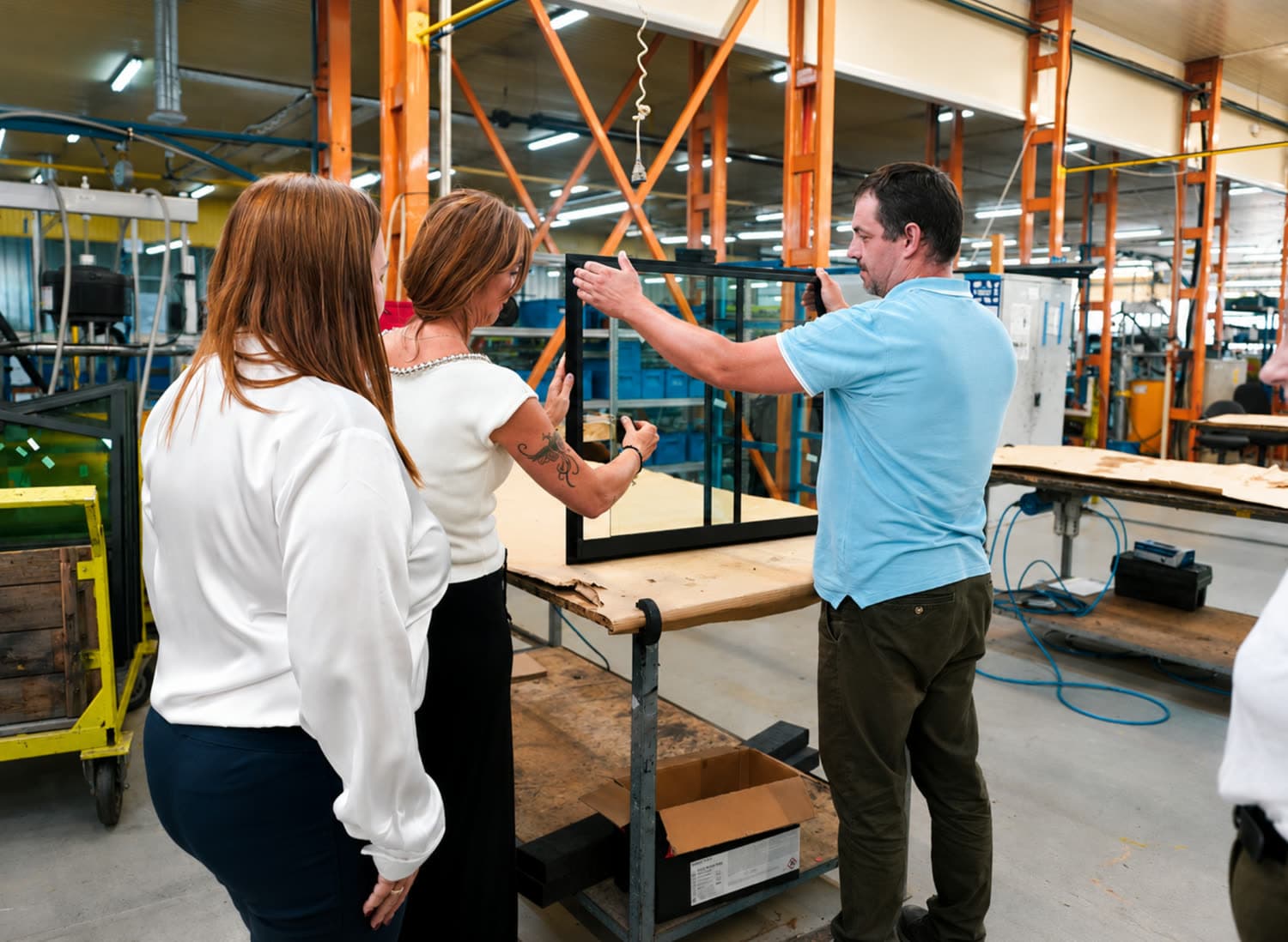 KÖNIG staff checking a finished double-glazed window frame on the assembly floor